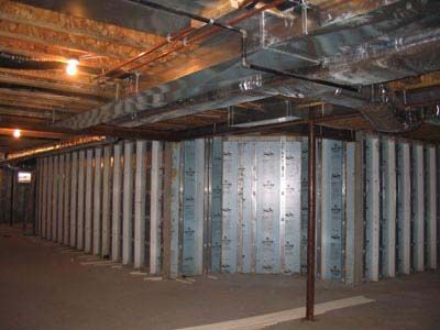 A basement with a lot of pipes coming out of the ceiling.