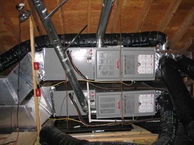 A stack of air conditioners sitting on top of each other in an attic.