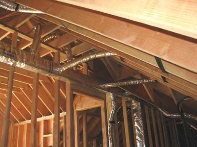 A house is being built with a lot of wood and aluminum ducting.