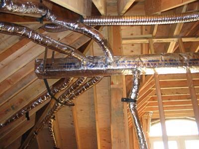 A bunch of pipes are hanging from the ceiling of a building