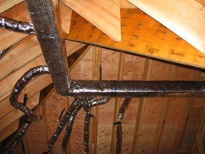A bunch of pipes are hanging from the ceiling of a building.
