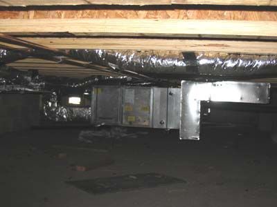 There is a ventilation system in the ceiling of a basement.