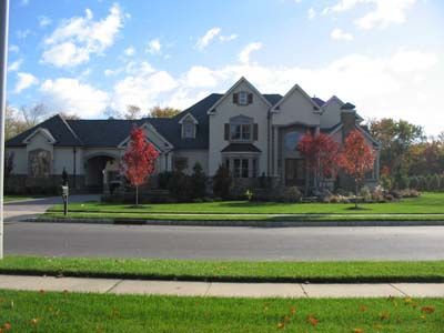A large house sits on the corner of a residential street