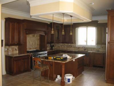 A kitchen with wooden cabinets and a large island in the middle.
