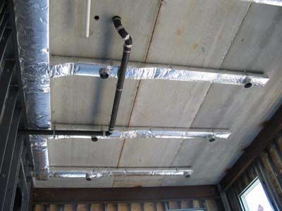 There are many pipes hanging from the ceiling of a building.