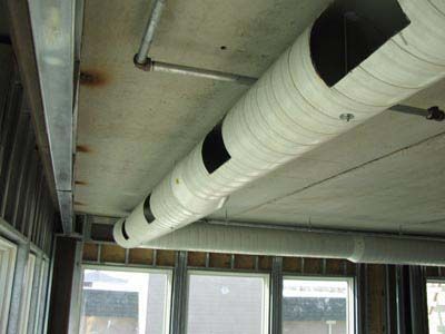 A large white pipe is hanging from the ceiling of a building.