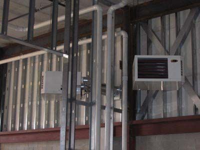 A room with a lot of pipes and a heater on the wall.
