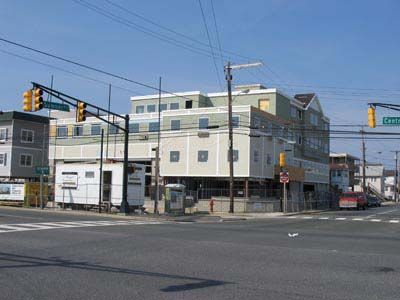 A large building is sitting on the corner of a street.