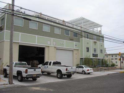 Two white trucks are parked in front of a building