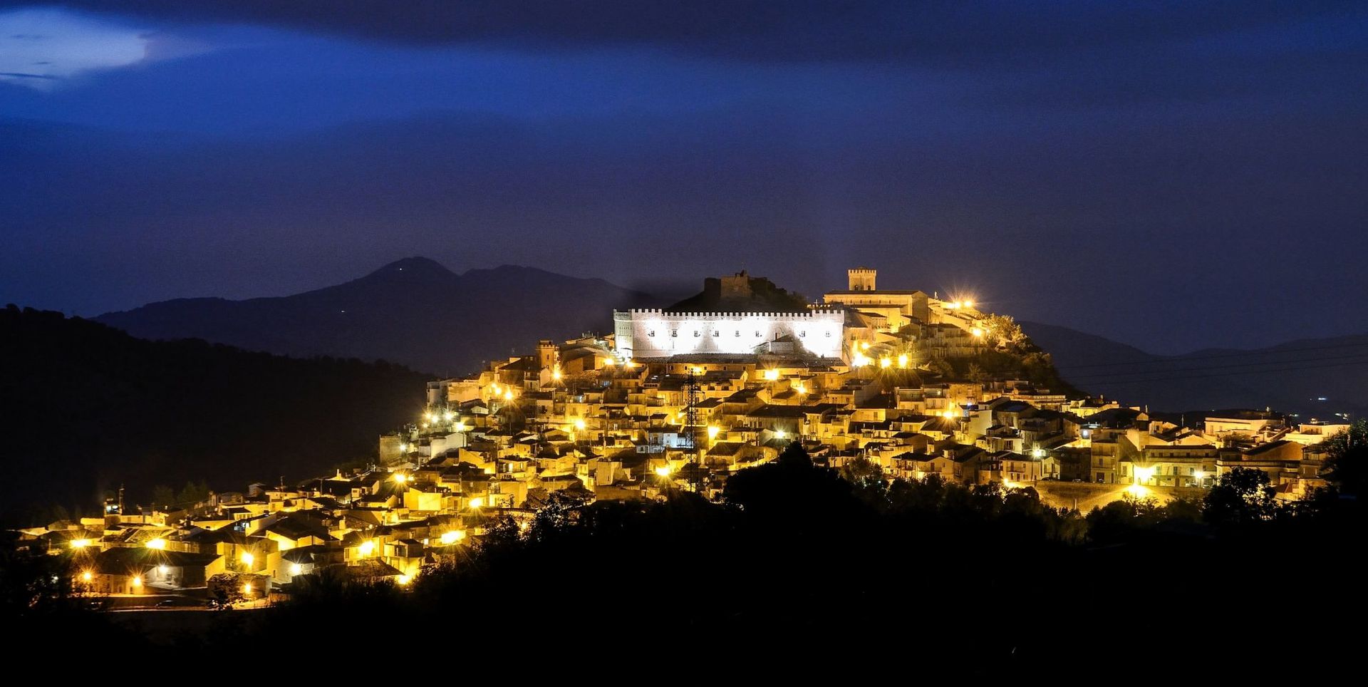 una città illuminata e vista delle montagne