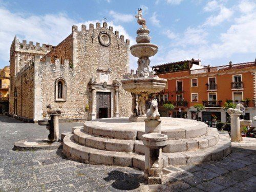 una fontana antica davanti a una cattedrale