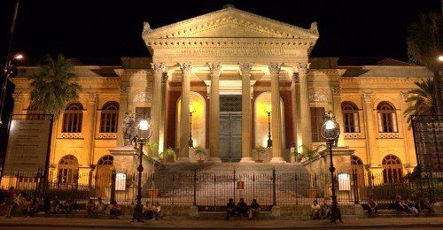 un palazzo con delle colonne e delle luci durante la sera