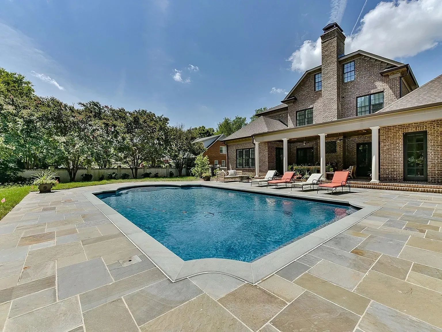 A large house with a large swimming pool in front of it