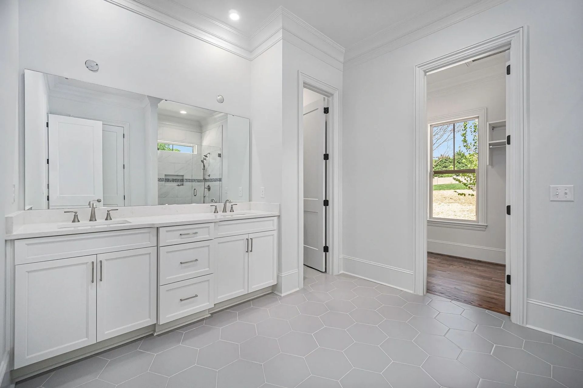 A bathroom with two sinks and a large mirror.