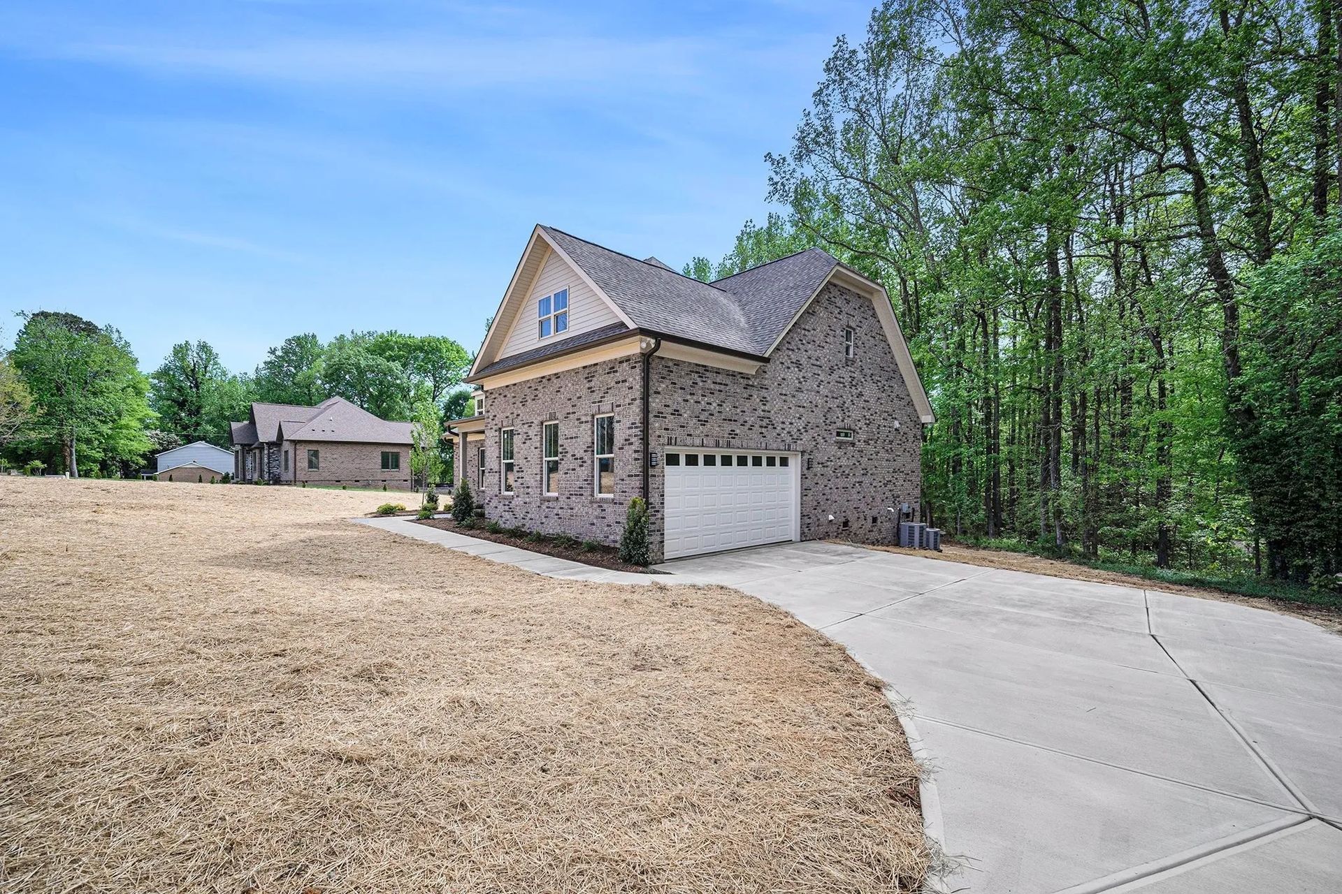 A house with a garage and a driveway in front of it.