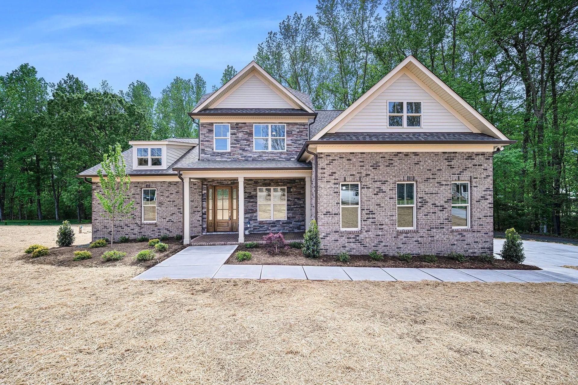 A brick house with a porch and a lot of windows