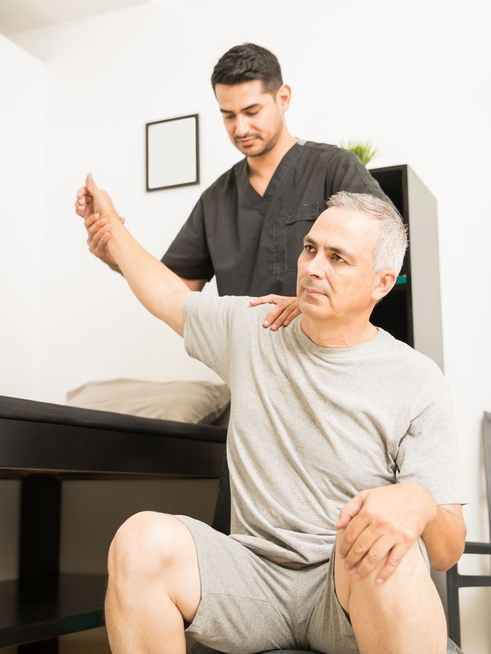 physiotherapist examining patient's arm