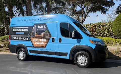 A car is parked in front of a building that says affordable flooring