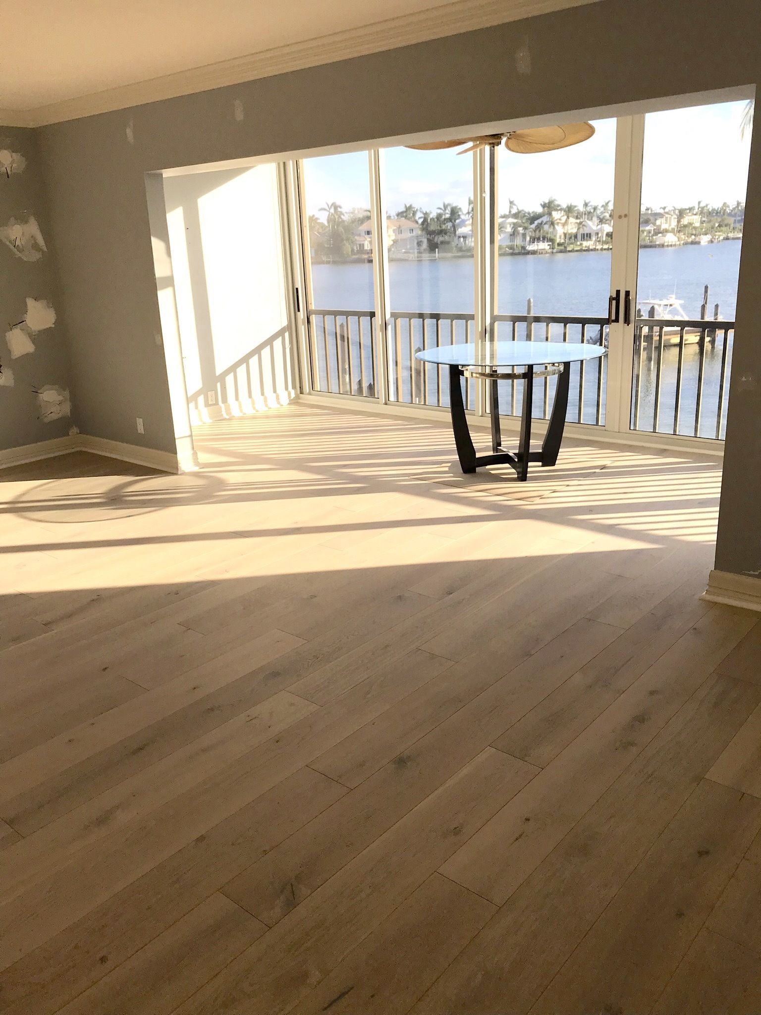An empty room with a table and a view of a body of water