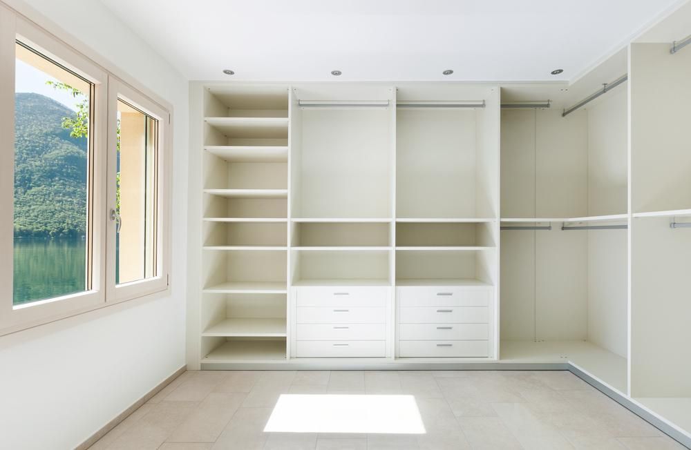 An Empty Walk In Closet With Lots Of Shelves And Drawers And A Window — North Coast Cabinetmaking Pty Ltd In Bowen, QLD