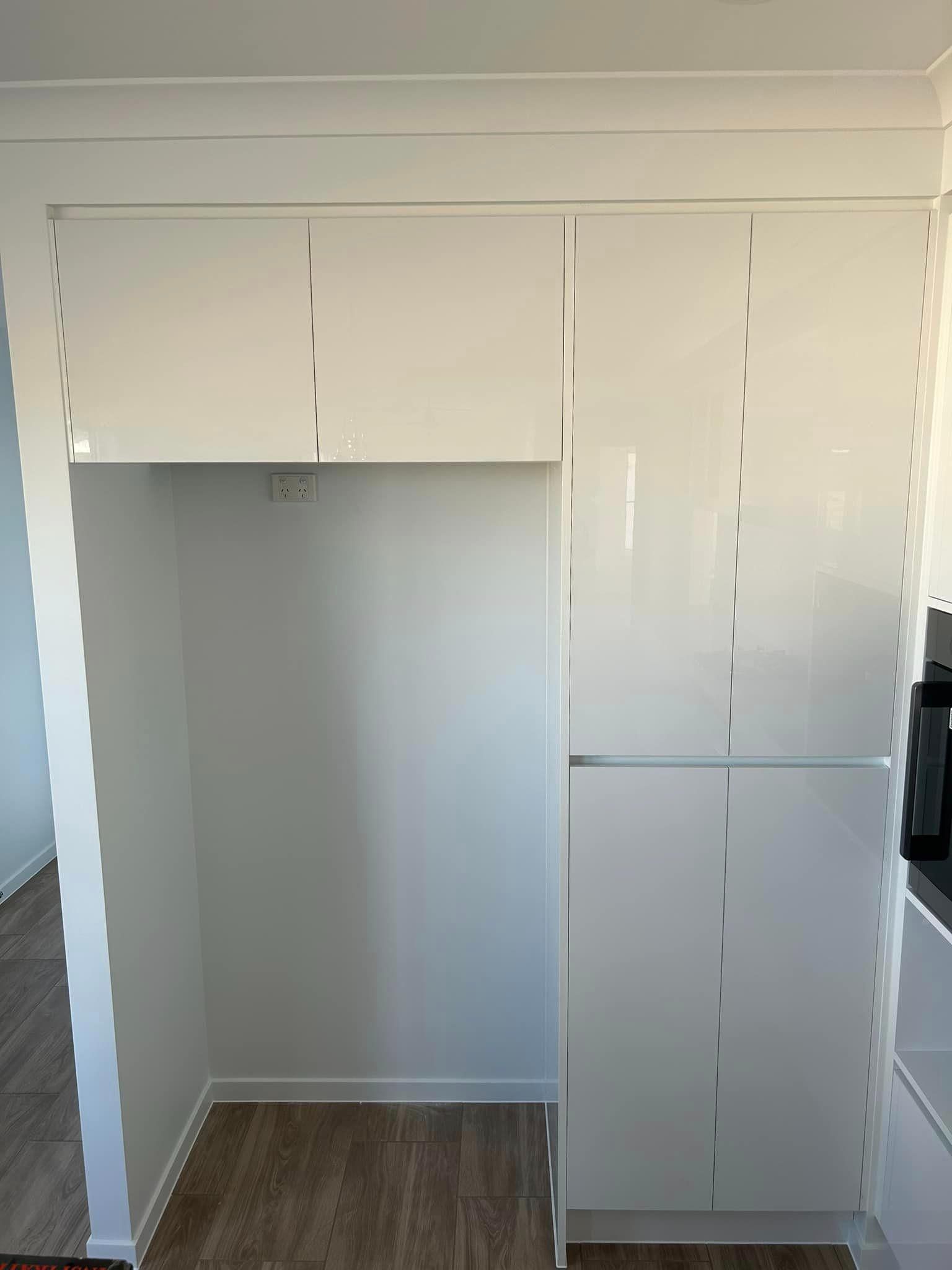 A Kitchen With White Cabinets And A Refrigerator — North Coast Cabinetmaking Pty Ltd In Proserpine, QLD