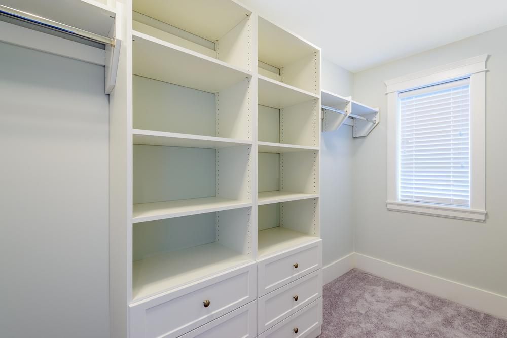 A Walk In Closet With Lots Of Shelves And Drawers And A Window — North Coast Cabinetmaking Pty Ltd In Whitsundays, QLD