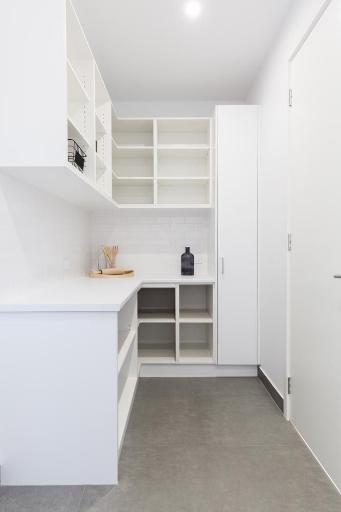 A Kitchen With White Cabinets And Shelves And A Vase On The Counter — North Coast Cabinetmaking Pty Ltd In Whitsundays, QLD