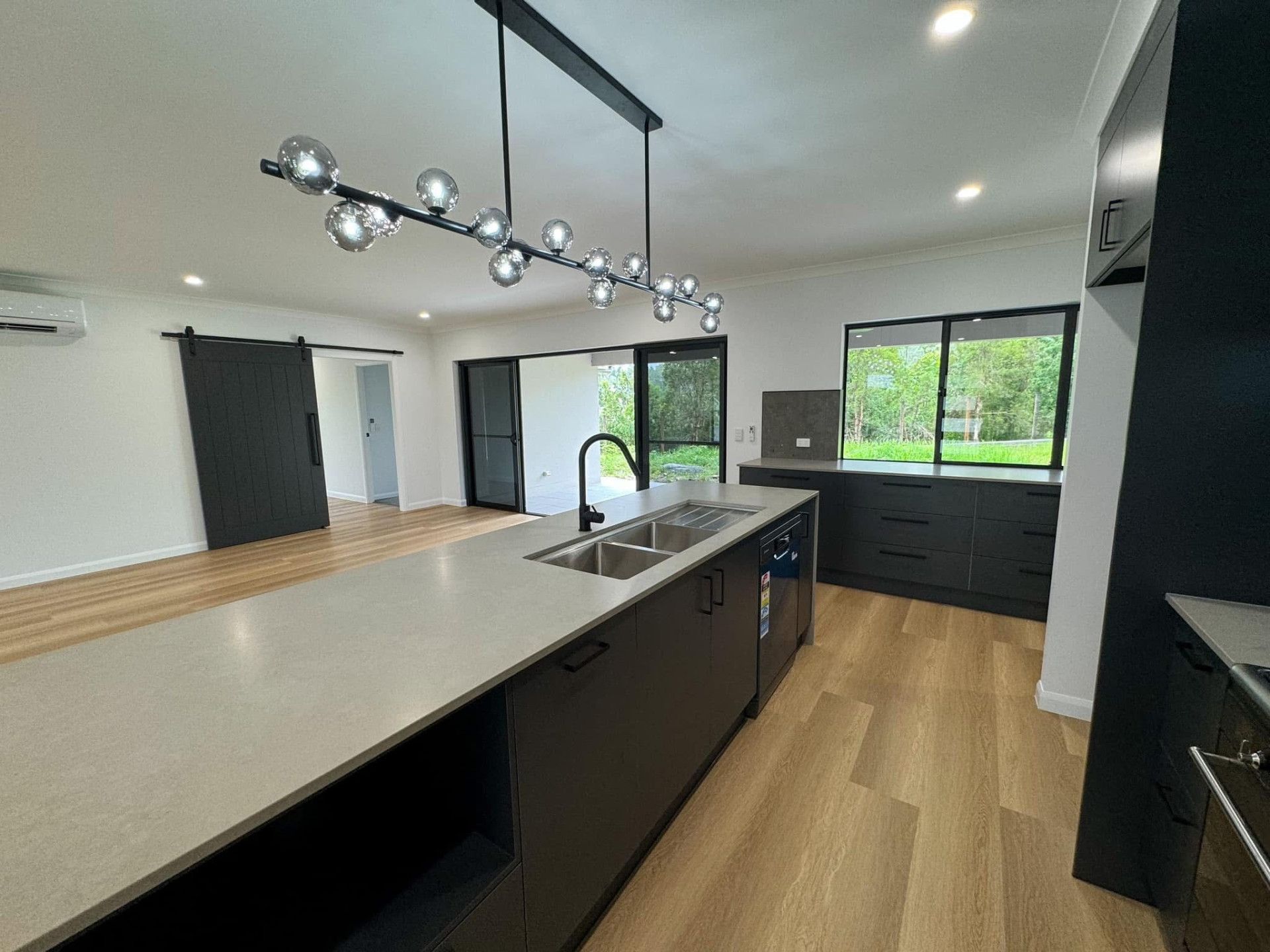 A Kitchen With A Black Cupboards And White Benchtop— North Coast Cabinetmaking Pty Ltd In Proserpine, QLD