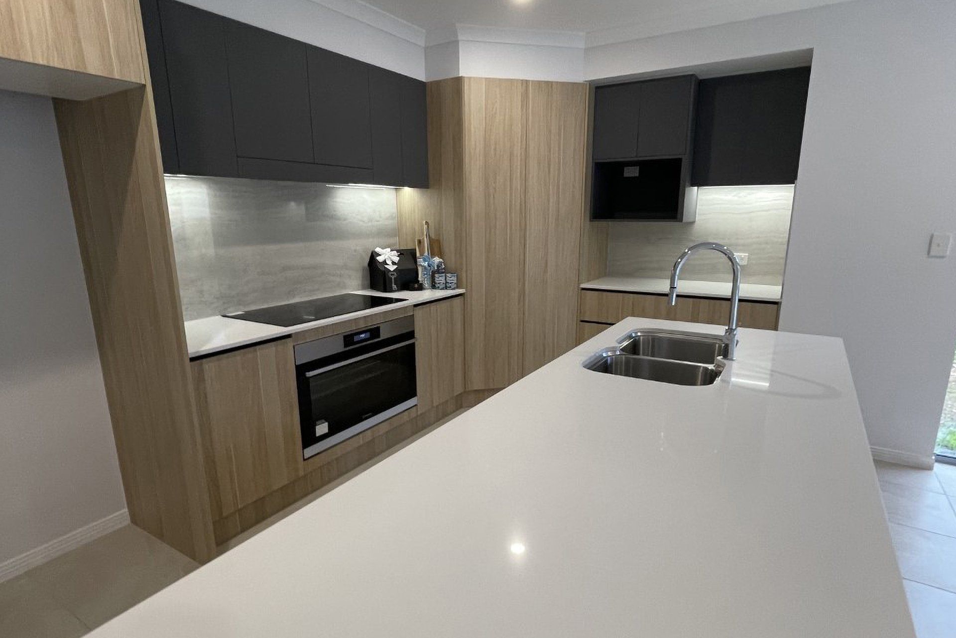 A Kitchen With Wooden Cabinets And A, Stainless Steel Appliances — North Coast Cabinetmaking Pty Ltd In Proserpine, QLD