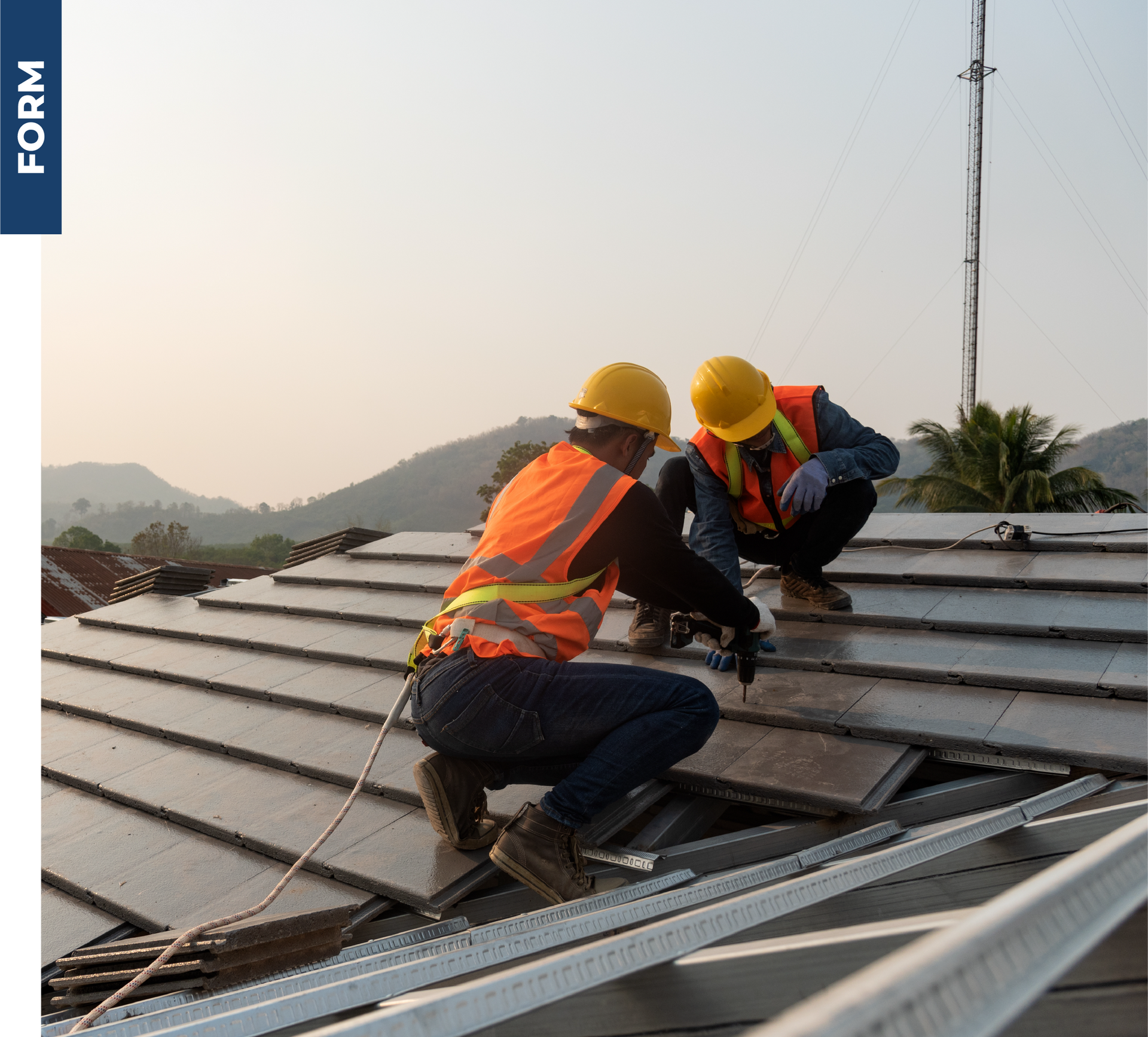 Two construction workers are working on the roof of a building.
