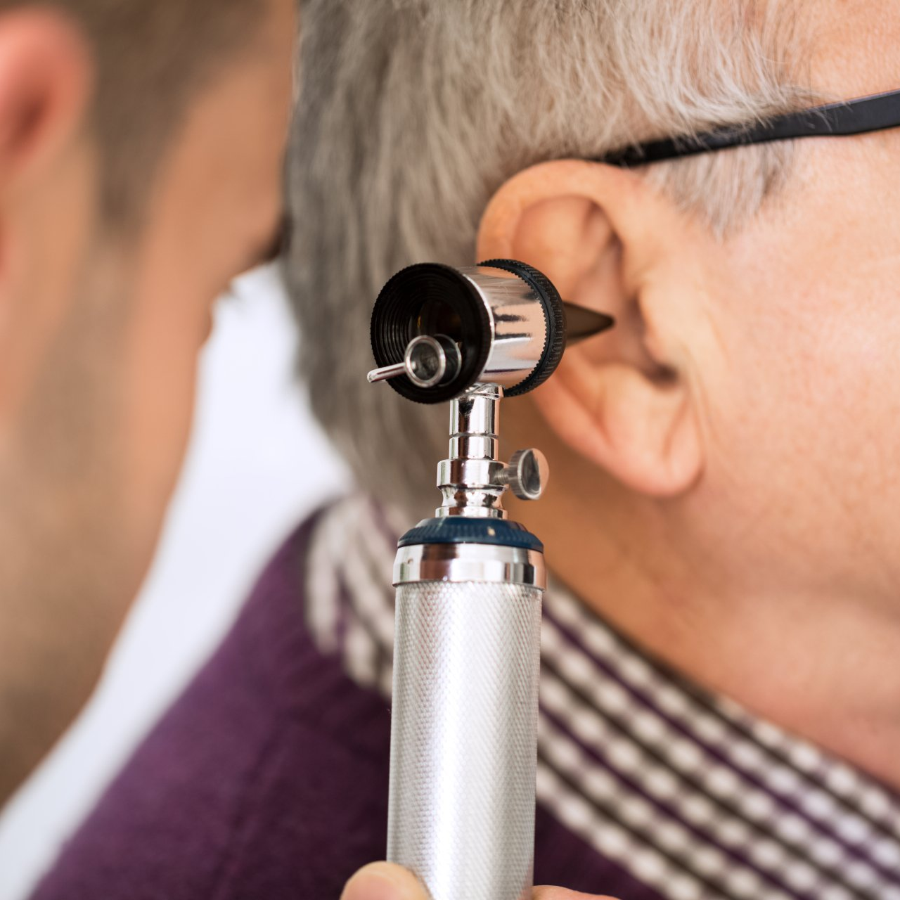 using otoscope to check old man's ear