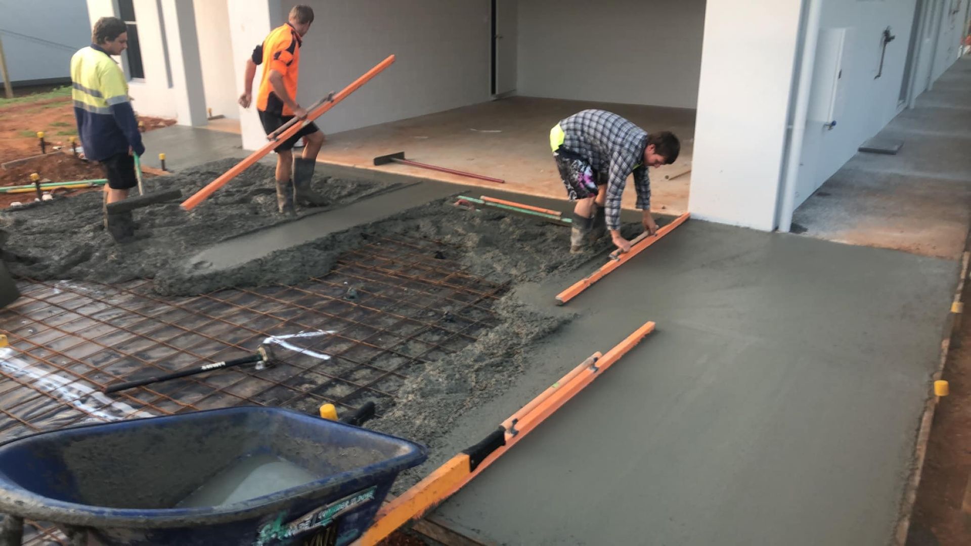 A Group Of Men Are Working On A Concrete Driveway — Value Concreting In Gordonvale, QLD