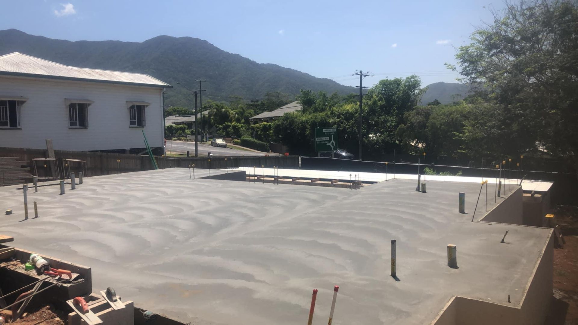 A Concrete Floor Is Being Built In Front Of A House With Mountains In The Background — Value Concreting In Gordonvale, QLD