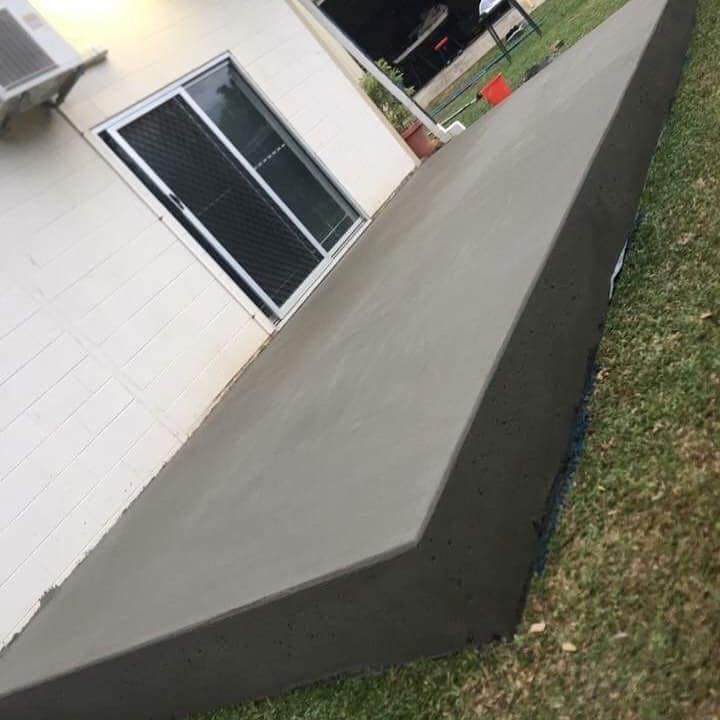 A Concrete Deck Is Sitting In The Grass In Front Of A House — Value Concreting In Gordonvale, QLD