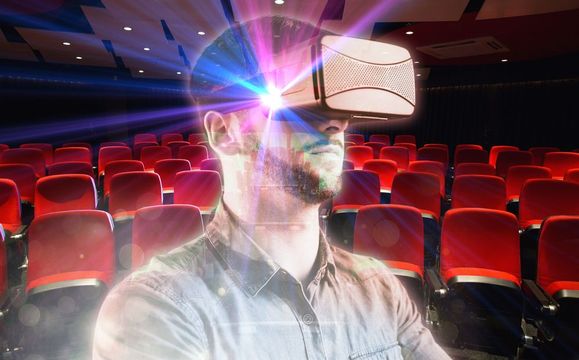 A man is wearing a virtual reality headset in a theater.