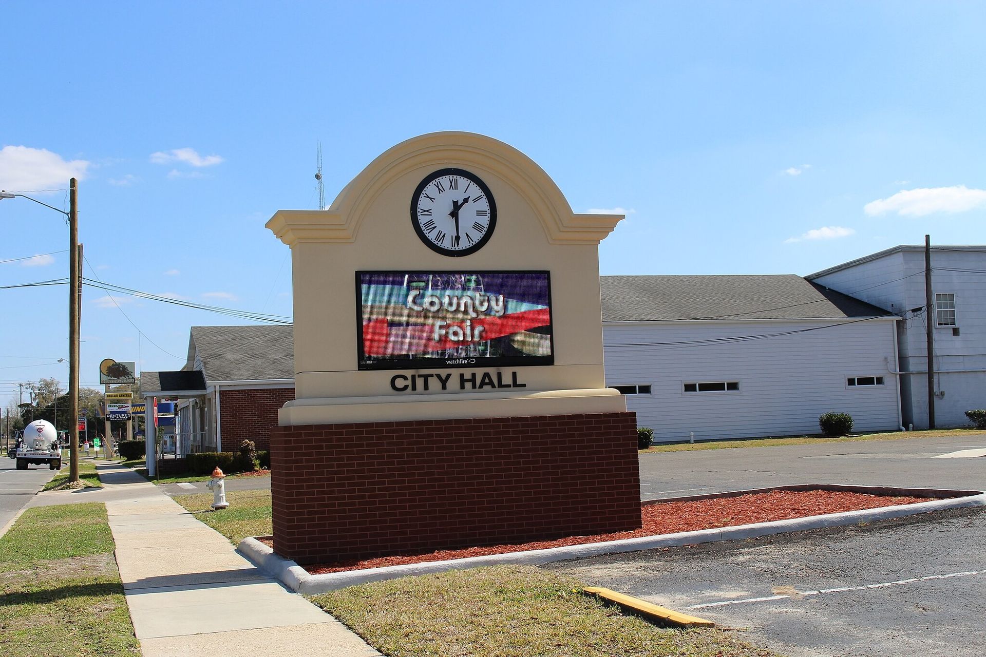 A neon sign that says drive thru open is lit up at night