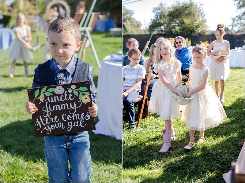 A boy is holding a sign that says `` uncle jimmy here comes your girl ''.
