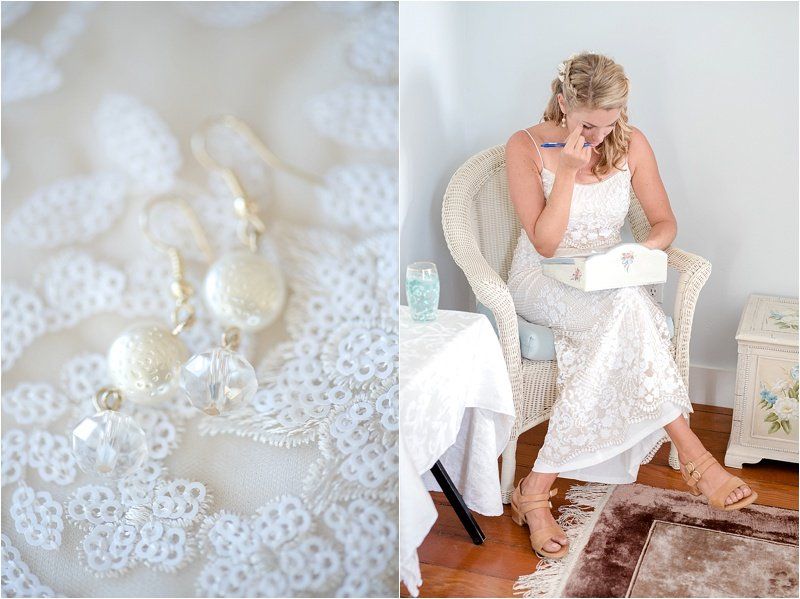 A woman in a white dress is sitting in a chair reading a letter.
