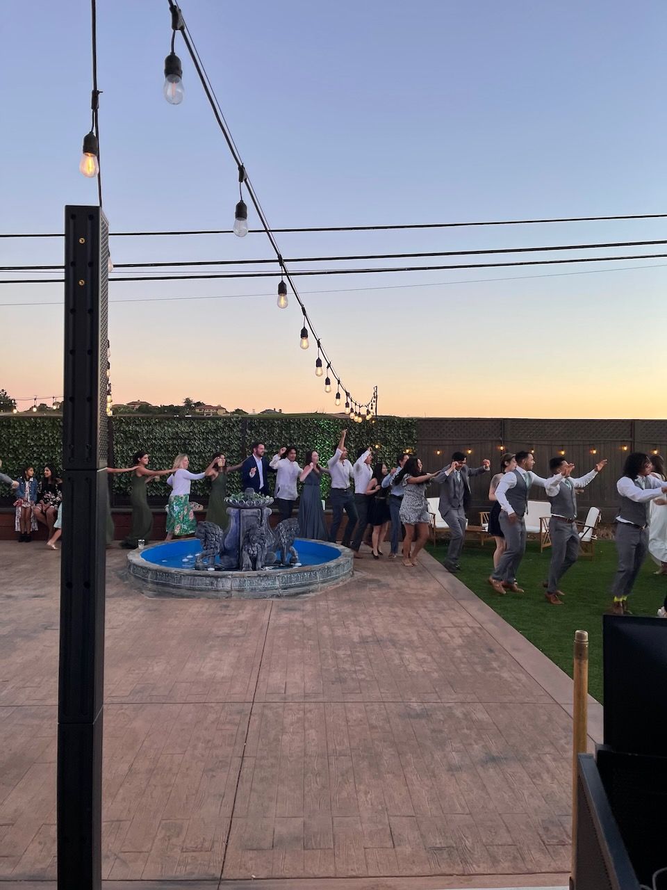 A group of people are dancing in front of a fountain.