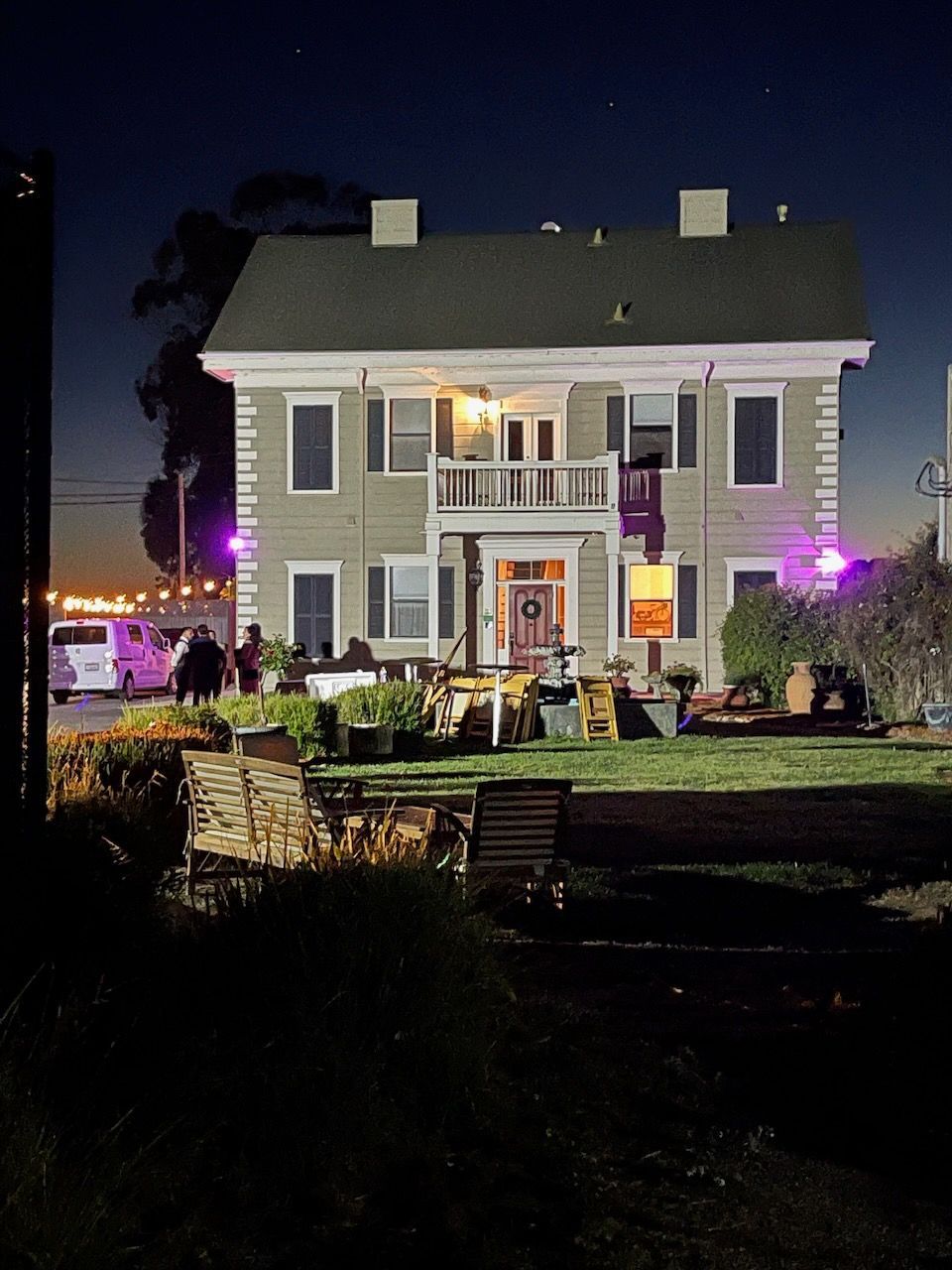 A large house is lit up with purple lights at night