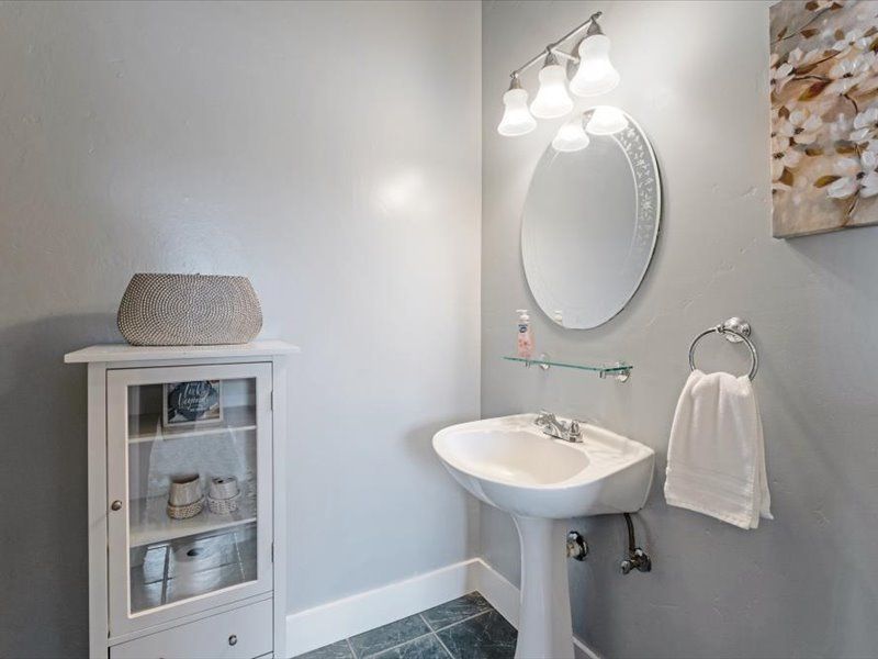 A bathroom with a sink , mirror and cabinet.