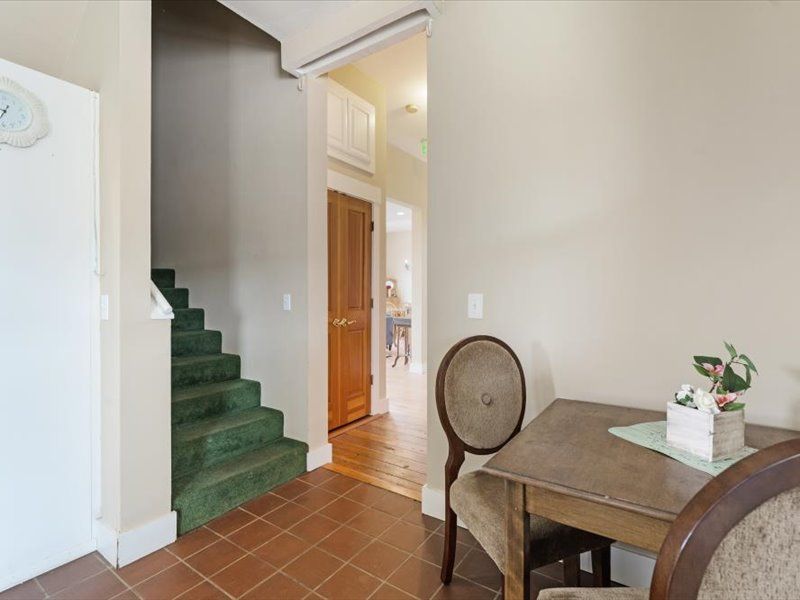 A room with a table and chairs and stairs in the background