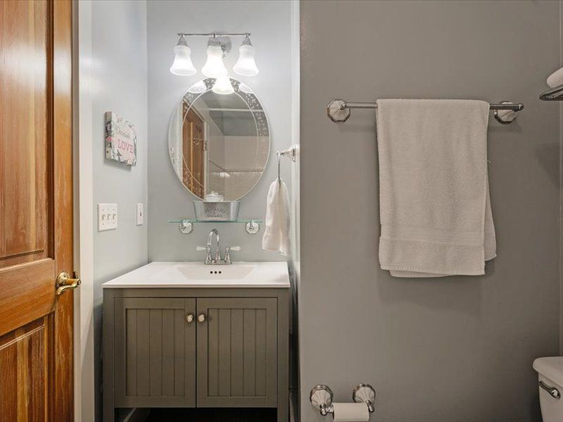 A bathroom with a sink , toilet and mirror.