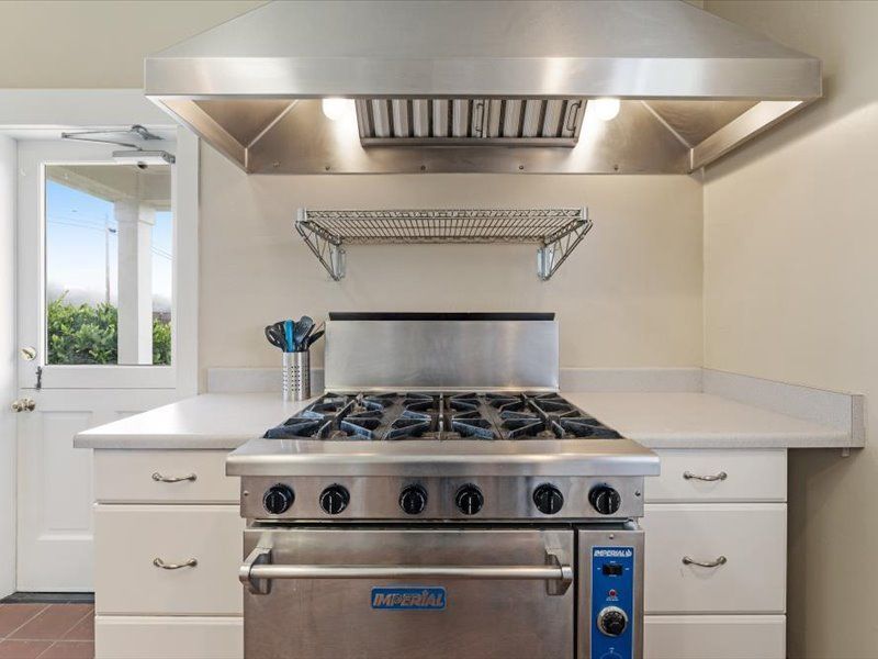 A stainless steel stove top oven is sitting on top of a counter in a kitchen.