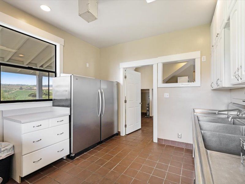 A kitchen with a stainless steel refrigerator and sink
