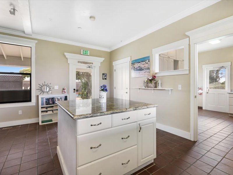 A kitchen with a large island and white cabinets