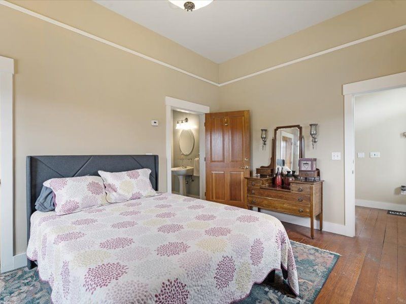 A bedroom with a bed , dresser and mirror.