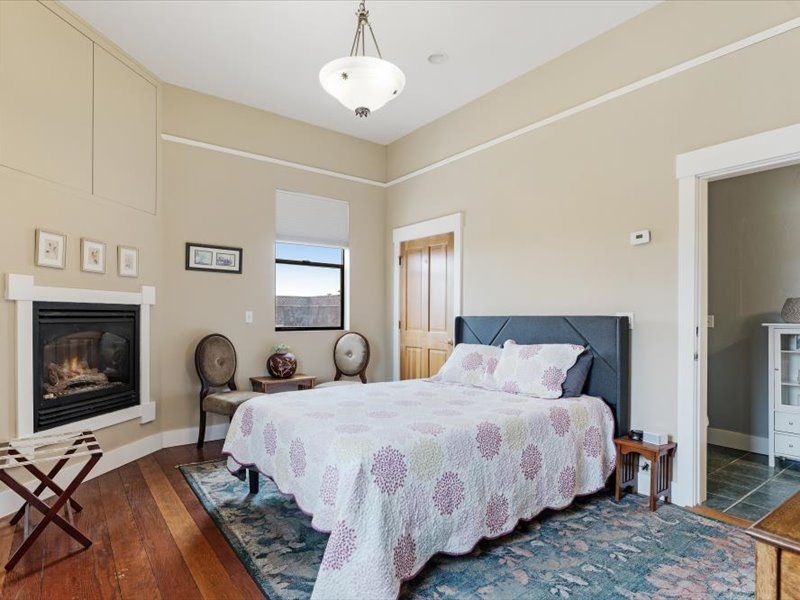 A bedroom with a king size bed and a fireplace.