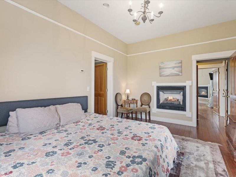 A bedroom with a king size bed and a fireplace.