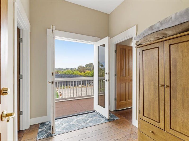 A room with a balcony and a dresser in it.